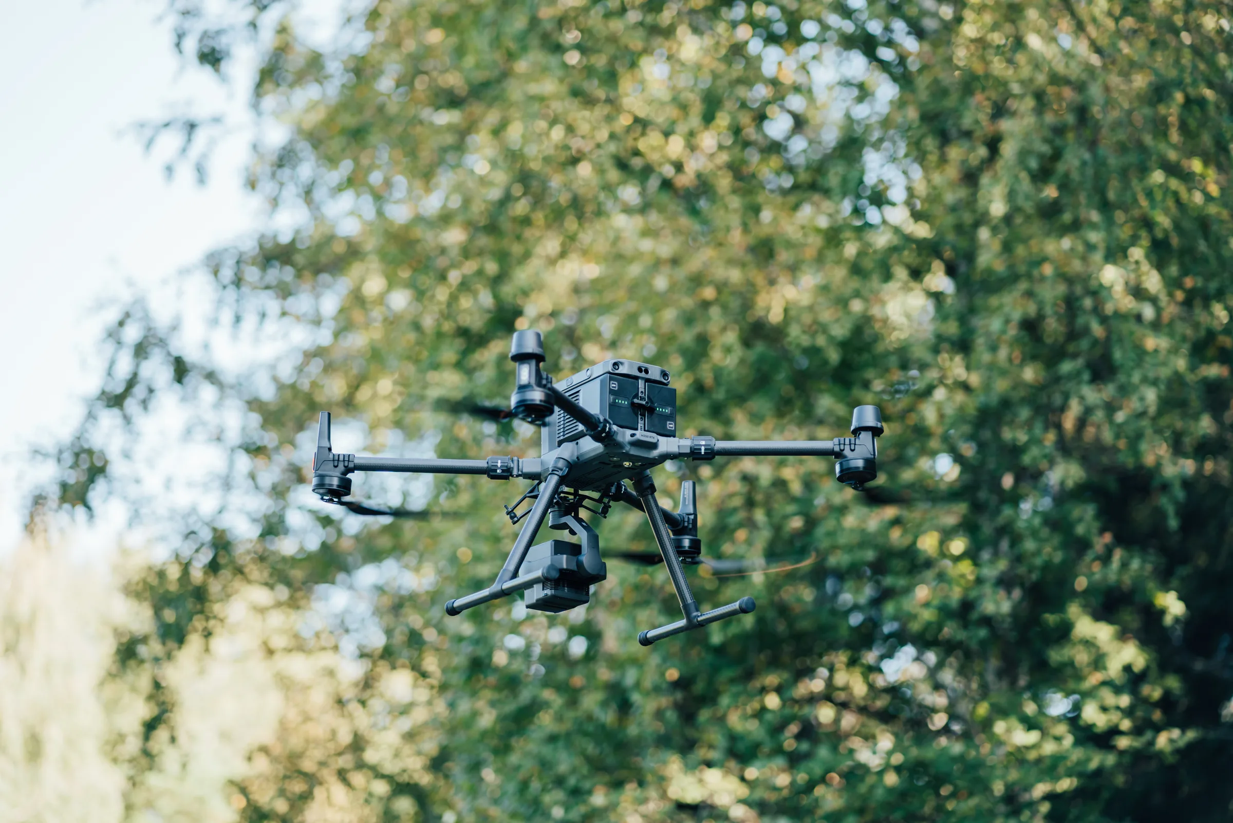 LIDAR drone in flight in front of trees