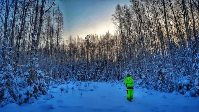 Mättekniker stakar ut en ny dikesdragning i snöig skog