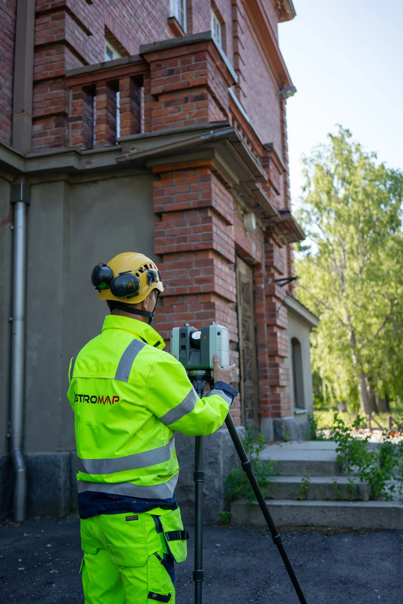 Surveyor scanning the facade of a brick building